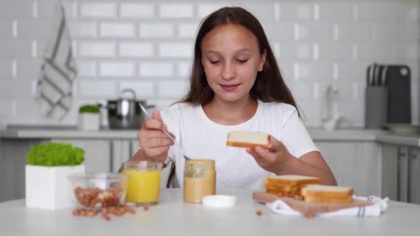Dziewczyna Dobrym Nastroju Robi Kanapkę Masłem Orzechowym Kuchni Wysokiej Jakości — Wideo stockowe