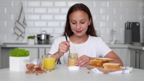 Seorang Gadis Dalam Suasana Hati Yang Baik Membuat Sandwich Selai — Stok Video