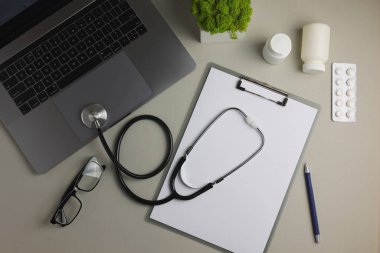 Doktor masası üst görünümü. Renkli arka planda farklı doktor aksesuarları. Haplar, gözlükler, steteskop ve defter. - Evet. Yüksek kalite fotoğraf