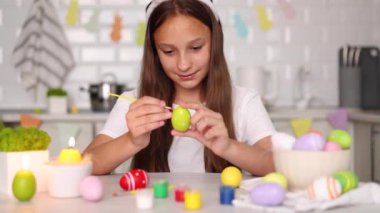 Paskalya yumurtaları için dekore edilmiş bir ev mutfağının içindeki genç bir kız. Yüksek kalite fotoğraf