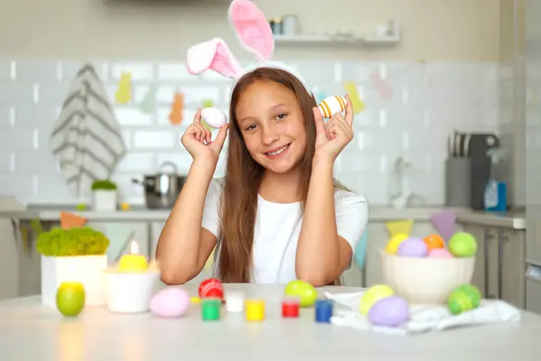 イースターのために装飾された家庭用キッチンの内装の10代の少女は イースターの卵を飾ります 高品質の写真 ロイヤリティフリーのストック画像