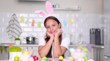 Paskalya yumurtaları için dekore edilmiş bir ev mutfağının içindeki genç bir kız. Yüksek kalite fotoğraf