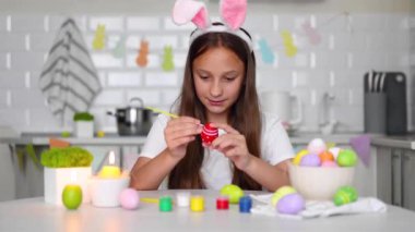 Paskalya yumurtaları için dekore edilmiş bir ev mutfağının içindeki genç bir kız. Yüksek kalite fotoğraf