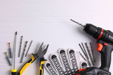 Üzerinde çeşitli matkap uçları bulunan kablosuz matkap mavi ahşap bir yüzeye yerleştirilir. DIY projeleri için mükemmel.