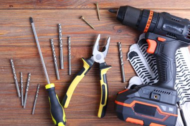 Üzerinde çeşitli matkap uçları bulunan kablosuz matkap mavi ahşap bir yüzeye yerleştirilir. DIY projeleri için mükemmel.