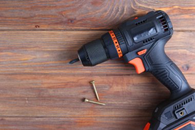 Üzerinde çeşitli matkap uçları bulunan kablosuz matkap mavi ahşap bir yüzeye yerleştirilir. DIY projeleri için mükemmel.