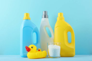Katlanmış giysiler, plastik ördek ve pastel arka planda deterjan içeren şirin bebek çamaşırları sahnesi..