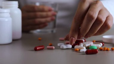 Halıya dağılmış haplarla potansiyel bir aşırı dozu tasvir eden dramatik bir sahne umutsuzluğu simgeliyor.