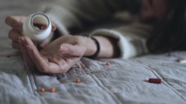 Halıya dağılmış haplarla potansiyel bir aşırı dozu tasvir eden dramatik bir sahne umutsuzluğu simgeliyor.