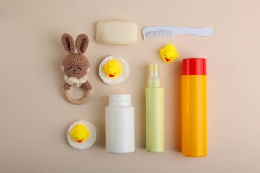 Çok güzel renkli, pembe bir arka planda çeşitli bebek bakım ürünleri ve oyuncakların sergilendiği bir daire.