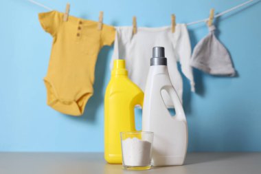 Katlanmış giysiler, plastik ördek ve pastel arka planda deterjan içeren şirin bebek çamaşırları sahnesi..