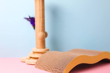 This stylish and modern cat scratch post features a unique and creatively curved mat for feline fun and enjoyment clipart