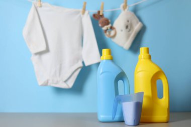 Katlanmış giysiler, plastik ördek ve pastel arka planda deterjan içeren şirin bebek çamaşırları sahnesi..