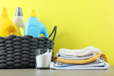 Katlanmış giysiler, plastik ördek ve pastel arka planda deterjan içeren şirin bebek çamaşırları sahnesi..