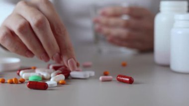 Halıya dağılmış haplarla potansiyel bir aşırı dozu tasvir eden dramatik bir sahne umutsuzluğu simgeliyor.