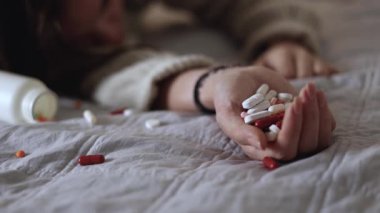 Halıya dağılmış haplarla potansiyel bir aşırı dozu tasvir eden dramatik bir sahne umutsuzluğu simgeliyor.