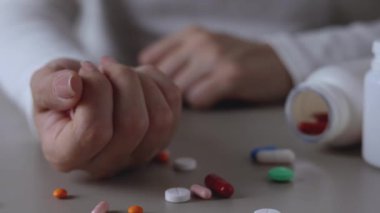 Halıya dağılmış haplarla potansiyel bir aşırı dozu tasvir eden dramatik bir sahne umutsuzluğu simgeliyor.