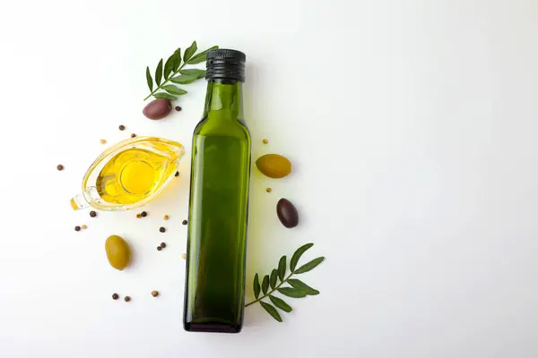 Zeytinyağı, zeytin yağı ve taze yapraklardan oluşan zarif bir estetik kompozisyon.