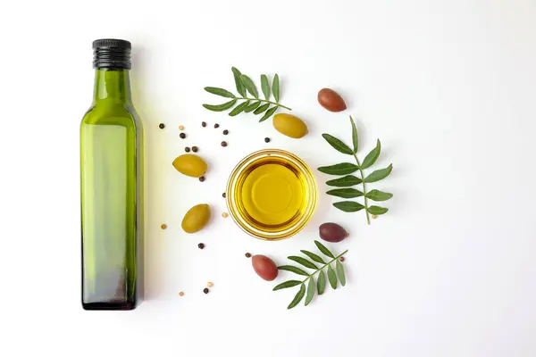 Zeytinyağı, zeytin yağı ve taze yapraklardan oluşan zarif bir estetik kompozisyon.