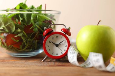 Renkli bir salatanın yanındaki yeşil elma dengeli bir yaşam tarzı için sağlıklı beslenme ve beslenmeyi somutlaştırır.