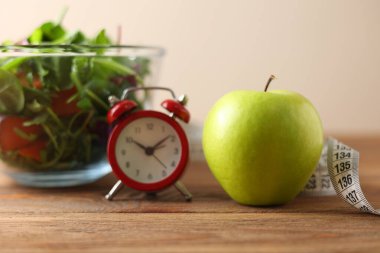 Renkli bir salatanın yanındaki yeşil elma dengeli bir yaşam tarzı için sağlıklı beslenme ve beslenmeyi somutlaştırır.