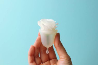 Çevre dostu regl bardağı. Parlak arka planda, kadınların ellerinde. Yüksek kalite fotoğraf