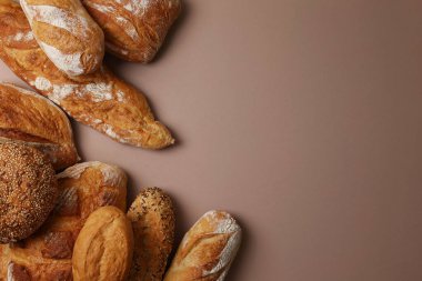 Canlı bir arkaplanda güzel bir şekilde sergilenen çeşitli taze pişmiş ekmeklerden oluşan hoş bir koleksiyon.