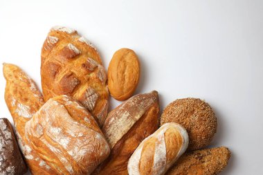 Canlı bir arkaplanda güzel bir şekilde sergilenen çeşitli taze pişmiş ekmeklerden oluşan hoş bir koleksiyon.