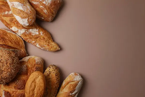 Canlı bir arkaplanda güzel bir şekilde sergilenen çeşitli taze pişmiş ekmeklerden oluşan hoş bir koleksiyon.