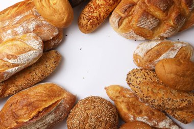 Canlı bir arkaplanda güzel bir şekilde sergilenen çeşitli taze pişmiş ekmeklerden oluşan hoş bir koleksiyon.