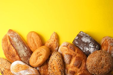 Canlı bir arkaplanda güzel bir şekilde sergilenen çeşitli taze pişmiş ekmeklerden oluşan hoş bir koleksiyon.