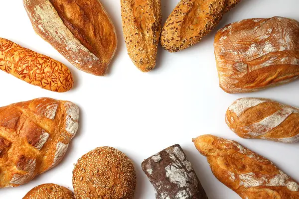 Canlı bir arkaplanda güzel bir şekilde sergilenen çeşitli taze pişmiş ekmeklerden oluşan hoş bir koleksiyon.