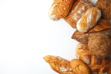 Canlı bir arkaplanda güzel bir şekilde sergilenen çeşitli taze pişmiş ekmeklerden oluşan hoş bir koleksiyon.