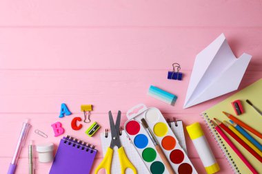 Renkli okul malzemeleri hafif bir arka planda okul sezonu için güzelce düzenlenmiş.