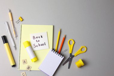 Renkli okul malzemeleri hafif bir arka planda okul sezonu için güzelce düzenlenmiş.