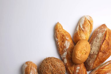 Canlı bir arkaplanda güzel bir şekilde sergilenen çeşitli taze pişmiş ekmeklerden oluşan hoş bir koleksiyon.