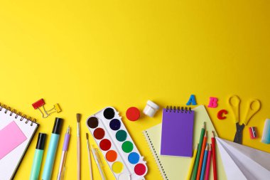 Renkli okul malzemeleri hafif bir arka planda okul sezonu için güzelce düzenlenmiş.