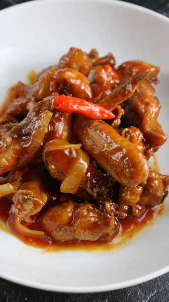 stock image ayam goreng rica rica, fried chicken from Manado Indonesia that has a spicy taste because it uses a lot of chili, served on a white plate, delicious eaten with white rice. 