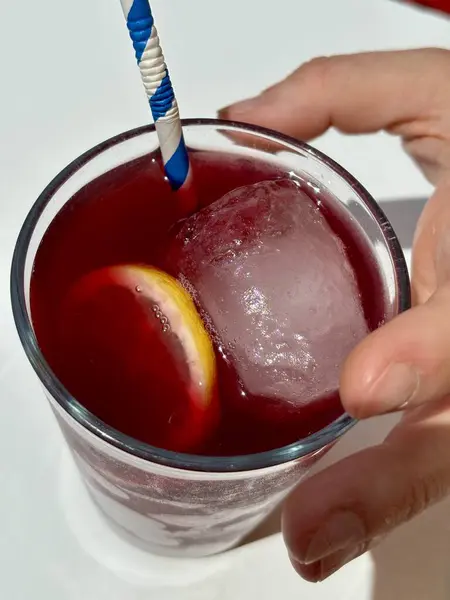 Elinde kırmızı sangria bardağı, Tinto de Verano, beyaz masanın üstü. Yüksek kalite fotoğraf