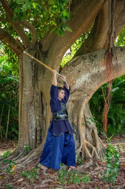 Ormanda bambu kılıçlı geleneksel kendo üniformalı adam.