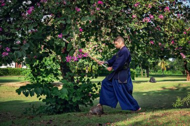 Ormanda bambu kılıçlı geleneksel kendo üniformalı adam.
