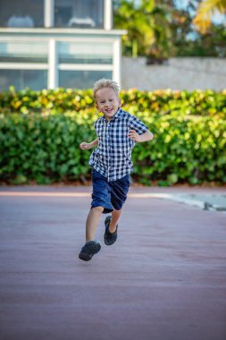 Kareli gömlekli neşeli bir sarışının yaz portresi..