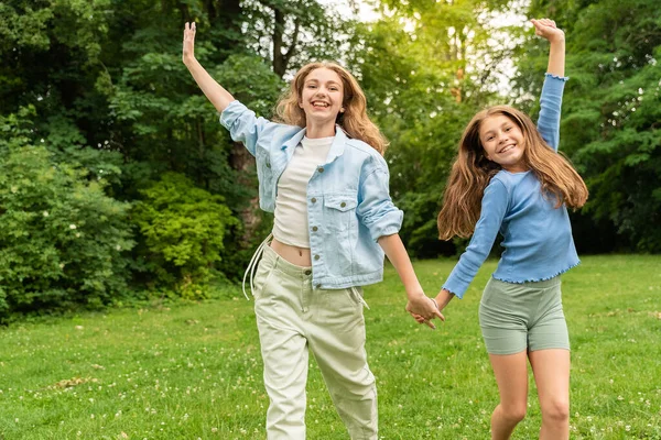 stock image Funny cute girls of European appearance walking in the Park, running together, holding hands and looking at camera joy laughter. The concept of respect, trust, joy, happy childhood and friendship.