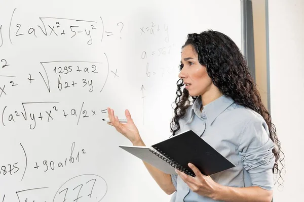 Portrait Puzzled Oriental Female Student Glasses Holding Notebook Pointing Blackboard — Stock Photo, Image