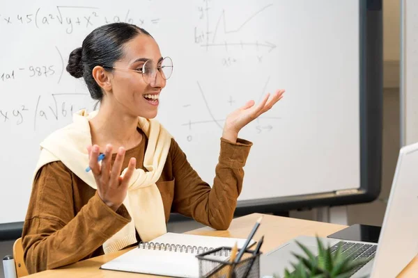 女性の若いアラブの学校の数学の先生 カレッジのチューターのコーチはウェブカムを見て 教室で話し ラップトップコンピュータ上のズーム会議コールによって仮想教育リモートクラスのオンラインレッスンを与えます — ストック写真