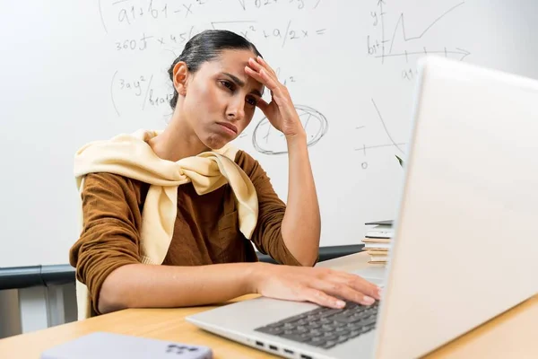 스트레스 히스패닉 머리를 그녀의 오피스에 노트북에 원격으로 우울한 피곤의 Onlin 로열티 프리 스톡 이미지