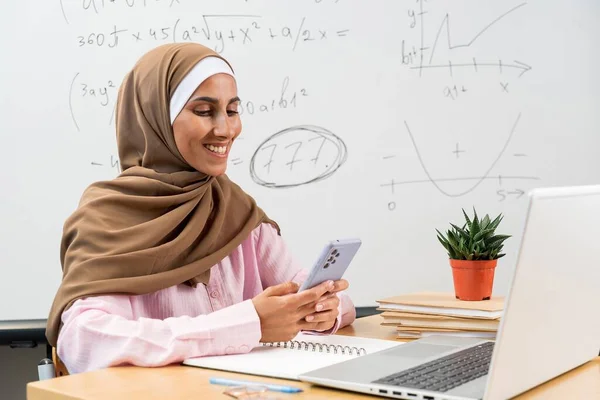 Güzel, genç, Arap bir öğretmen elinde telefonla bir sınıfta oturur ve ekrana bakar. Özel öğretmen yeni bir proje hakkında konuşuyor. Okulun başlangıcı. Çalışma alanında başarılı bir iş