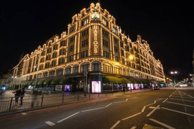 LONDON, UK - FEB 29, 2016: The famous Harrods department store in the evening of February at Knightsbridge in London, UK. Harrods is the biggest department store in Europe clipart