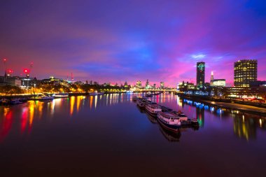 Gündoğumunda Thames nehrinin güney kıyısındaki Londra gökyüzü manzarası. İngiltere
