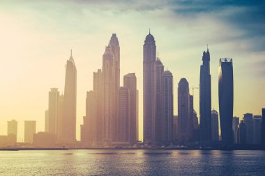 Gürültü ve tahıl etkisiyle Dubai marinasının klasik gündoğumu görüntüsü 